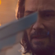 A close-up of Keanu Reeves holding a Game Award and questioning everything.